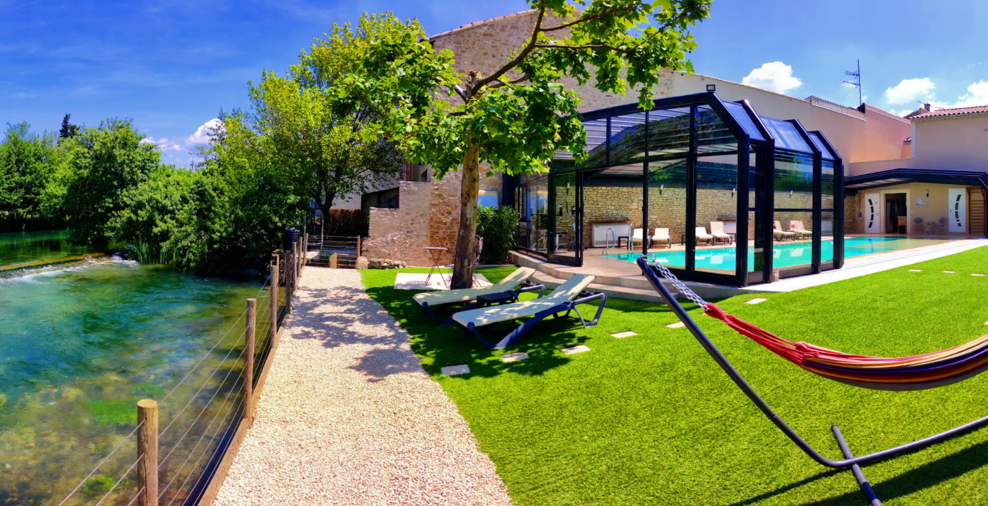 Piscine et terrasses en bord de Sorgue, avec salons de jardin, bains de soleil et hamacs, pour une invitation à la sieste